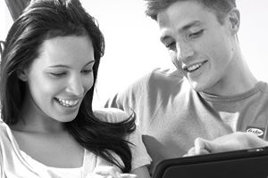 Par sedi na kauču i gleda u tablet