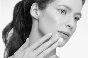 Žena rukom dodiruje lice.