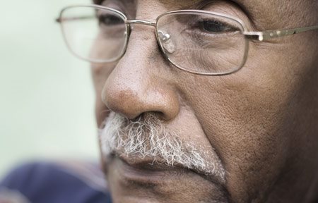 Stariji čovek sa tamnom kožom i vidnim nazolabijalnim naborima