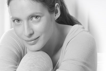 Žena naslanja glavu na svoje koleno.