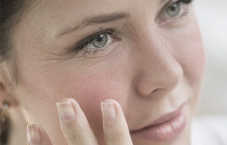 Žena rukom dodiruje lice