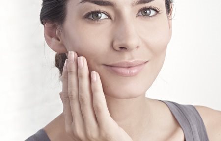 Žena nanosi kremu na lice