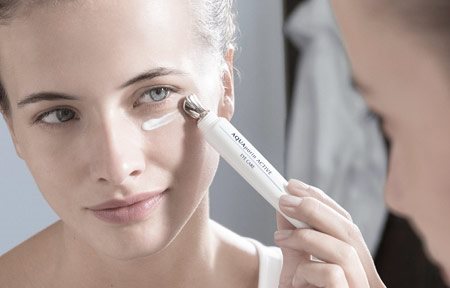 Žena nanosi kremu za negu područja oko očiju